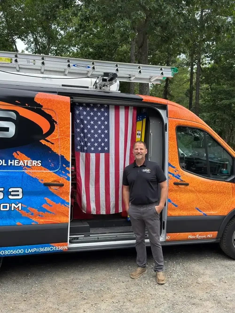 Dustin's mechanical technician standing in front of truck with american flag