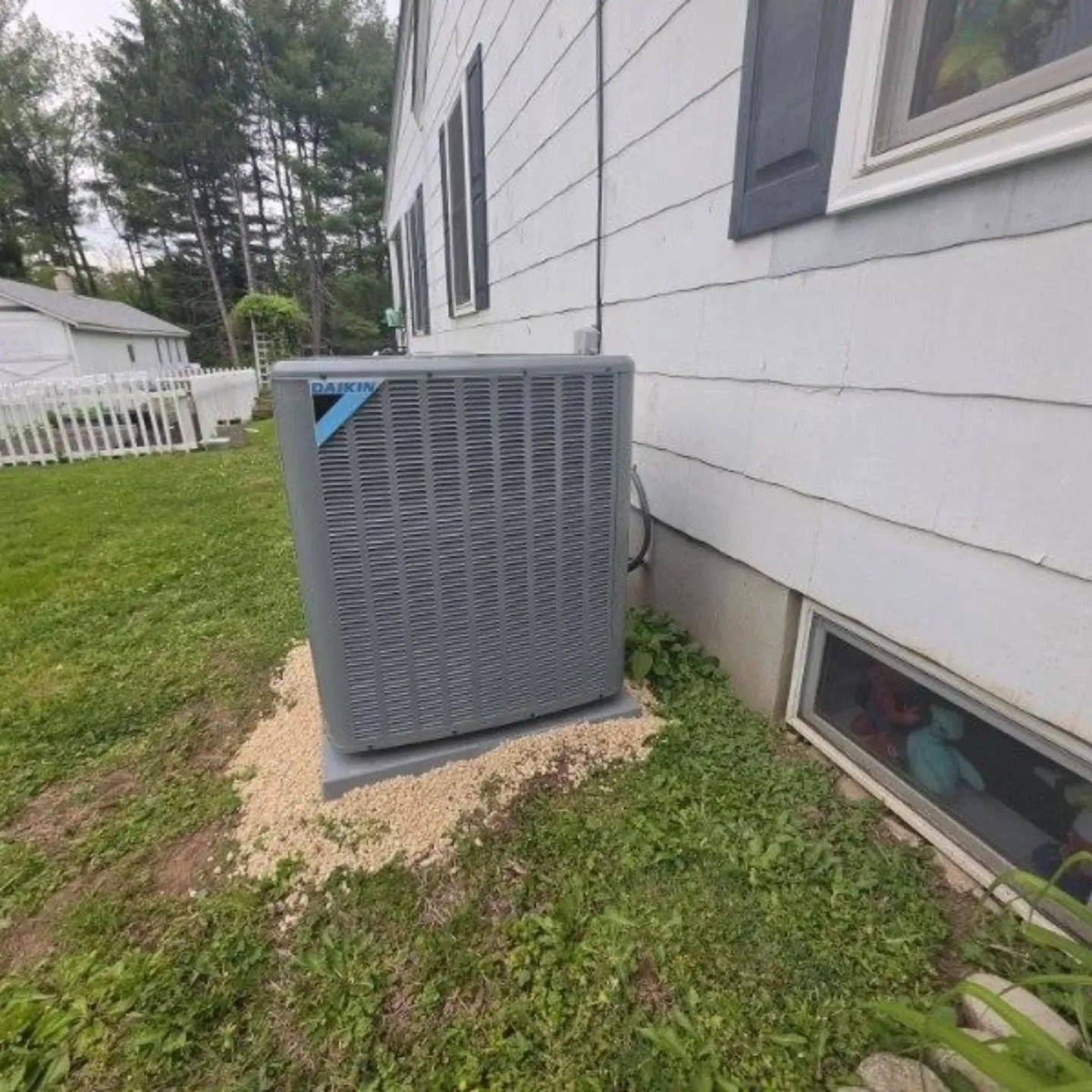 Daikin heat pump condenser unit installed by Dustin's Home Services on a gravel pad in New Egypt, N