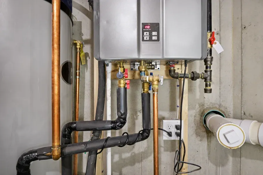 Installed by Dustin's Mechanical, this silver tankless water heater features copper piping in New Egypt, NJ