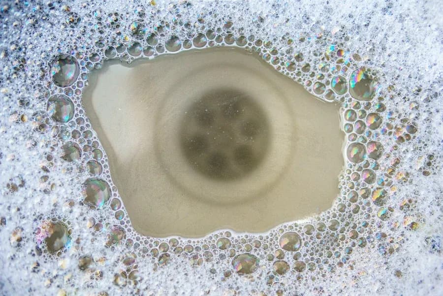 Close-up of a clogged sink drain with soap suds, a job for Dustin's Plumbing drain cleaning in New Egypt, NJ