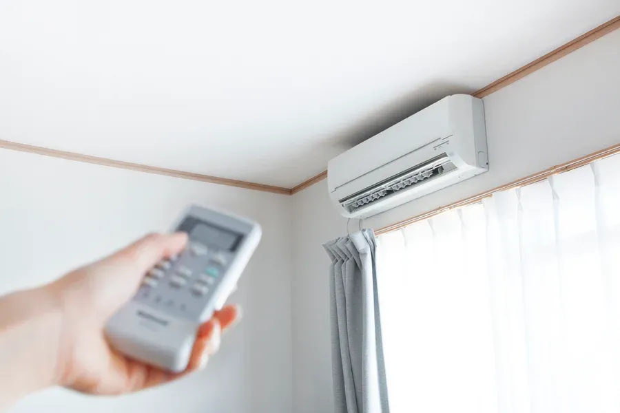 Mini split heat pump unit inside New Egypt home being controlled by remote