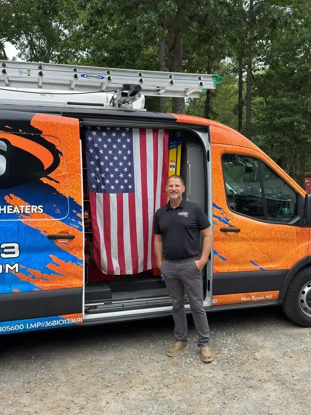 Dustin's mechanical technician standing in front of truck with american flag
