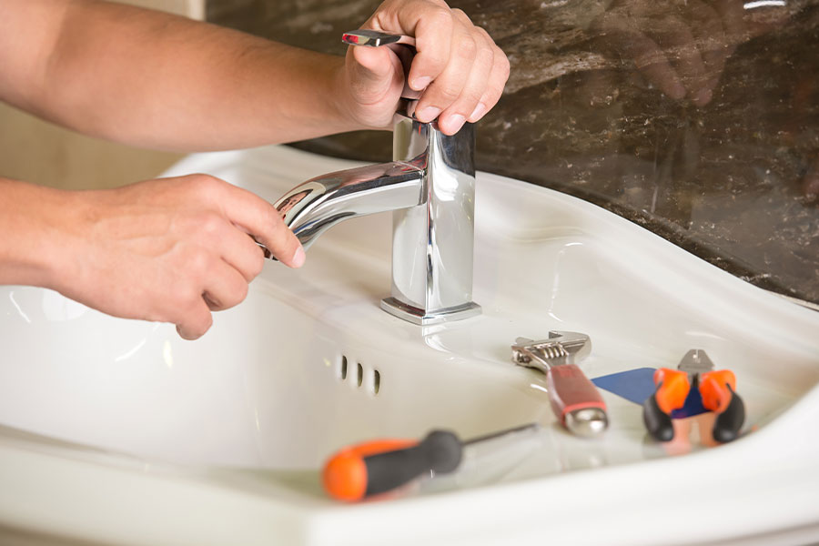Plumber installing or repairing a bathroom faucet