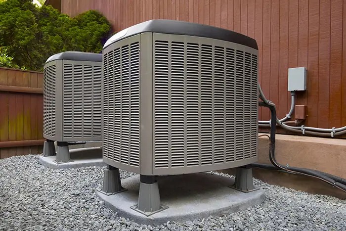 Two outdoor air conditioning units installed on elevated platforms